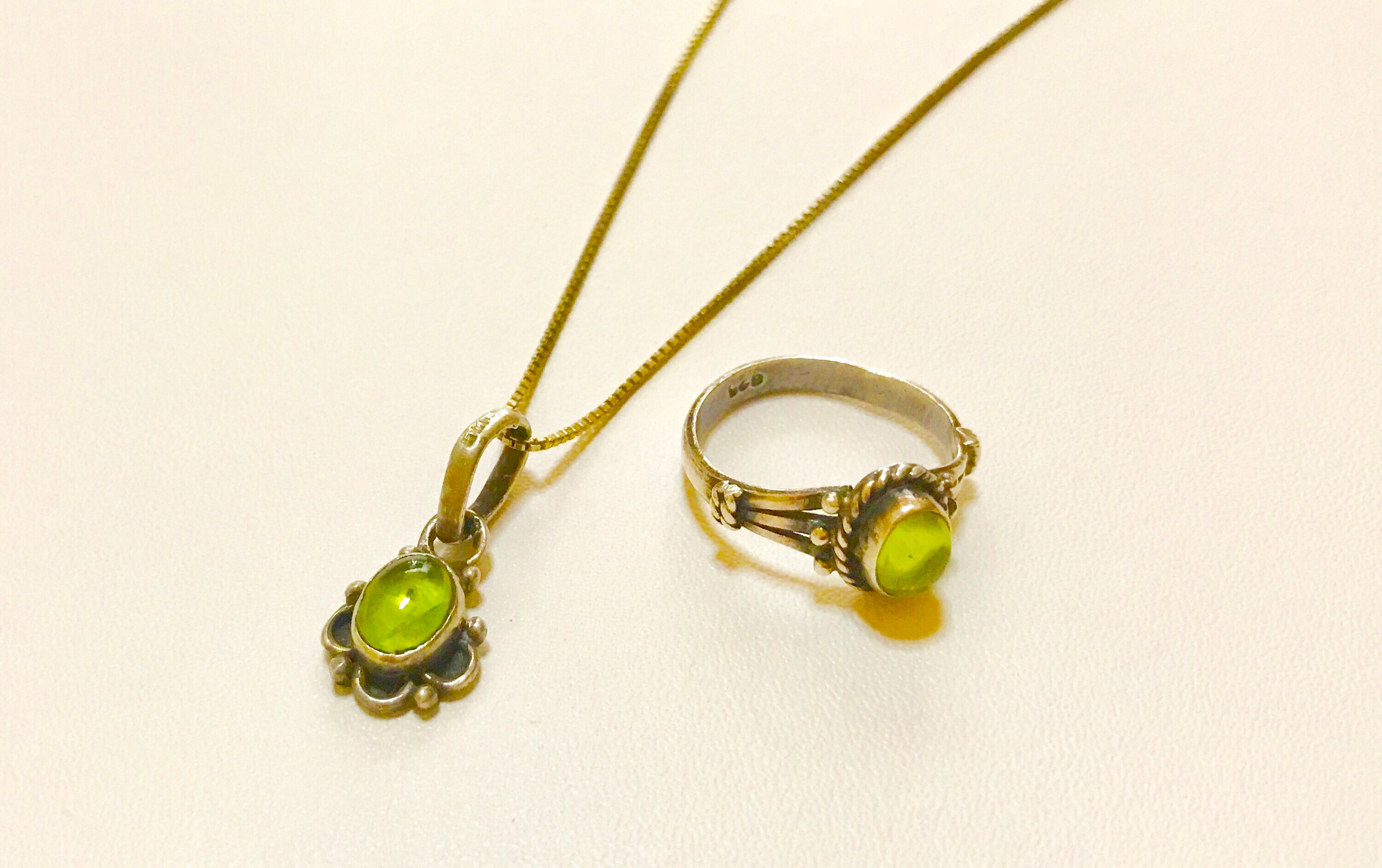 緑の石が付いたネックレスとリングのペア