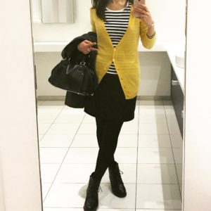 ボーダーTシャツにイエローのカーディガンを重ね着し、ブラックのミニスカートを合わせたコーディネート。